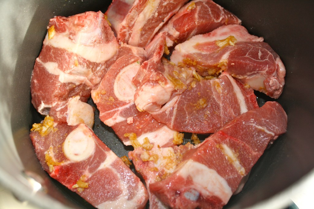 The goat, rubbed with the garlic and spices before browning in the pot.